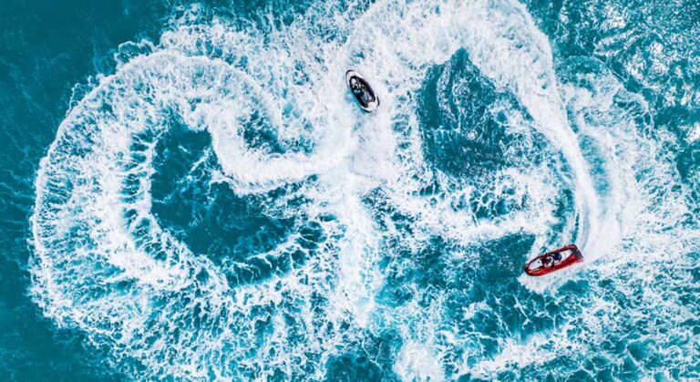 dwa wodne skutery wykonują akrobacje na wodzie