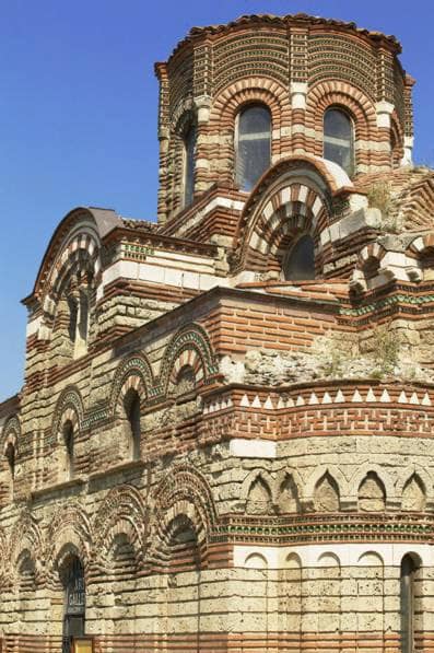 Fasada Cerkwi Chrystusa Pantokratora w Nesebyrze — bizantyjska dekoracja z naprzemiennych warstw cegły i kamienia, ceramiczne rozety