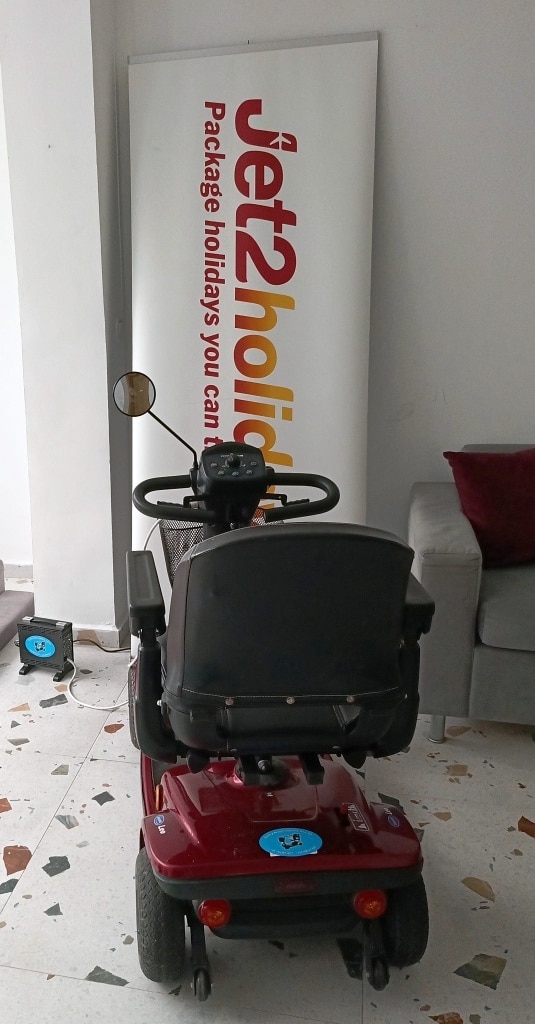 Wózek elektryczny w hotelu na tle napisu Jet2Holiday